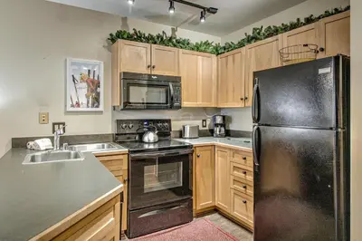 a kitchen with wooden cabinets and a black refrigerator at Keystone Condo 8380 in Keystone