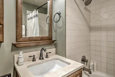 a bathroom with a sink and a mirror and a tub at Keystone Condo 8380 in Keystone