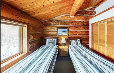 a bedroom with two beds in a log cabin at Mountain Basecamp Hot Tub plus Pool Table in Silverthorne