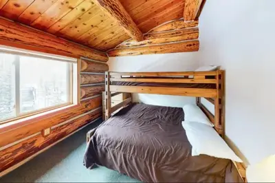 a bedroom with a bunk bed in a log cabin at Mountain Basecamp Hot Tub plus Pool Table in Silverthorne