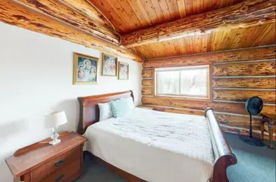 a bedroom with a bed in a log cabin at Mountain Basecamp Hot Tub plus Pool Table in Silverthorne
