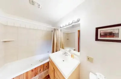 a bathroom with a sink and a tub and a mirror at Mountain Basecamp Hot Tub plus Pool Table in Silverthorne