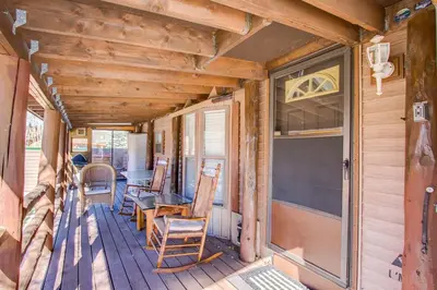 a porch of a cabin with chairs and a table at #84 Tiger Run in Breckenridge