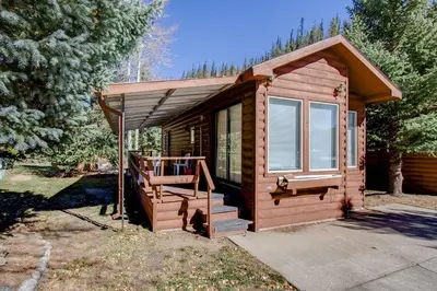 a small wooden cabin with a porch and a staircase at #244 Tiger Run in Breckenridge