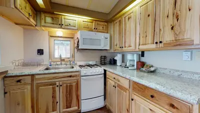 a kitchen with wooden cabinets and a white stove top oven at #244 Tiger Run in Breckenridge