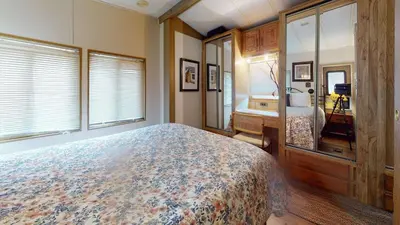 a bedroom with a bed and a desk and windows at #244 Tiger Run in Breckenridge