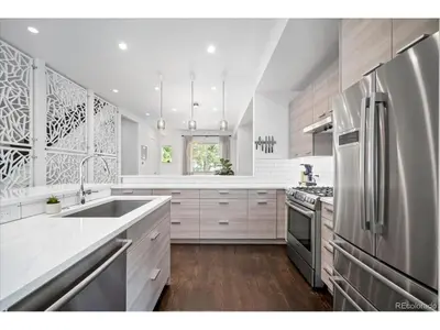 a kitchen with white cabinets and a stainless steel refrigerator at The Sage Sanctuary in Denver