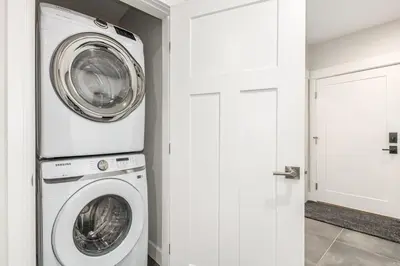 a washer and dryer in a white laundry room at Stylish Grand Lake Retreat - King Bed - Walk to Lake in Grand Lake