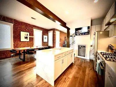 a kitchen with a brick wall and a counter top at UPTOWN CASTLE - CITY VIEWS - THEATER & CONVENTION DISTRICT! in Denver