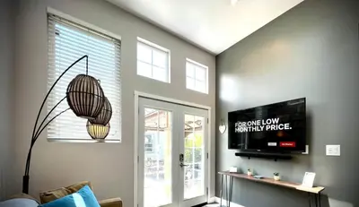 a living room with a television and a pendant light at UPTOWN CASTLE - CITY VIEWS - THEATER & CONVENTION DISTRICT! in Denver