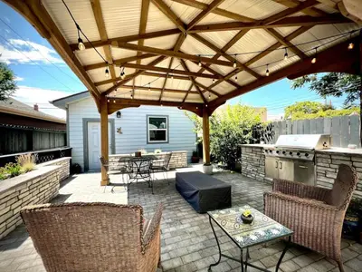 a patio with a wooden pergola and a grill at UPTOWN CASTLE - CITY VIEWS - THEATER & CONVENTION DISTRICT! in Denver