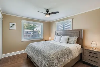 a bedroom with a bed and two windows at Bright and Cozy Ranch Style House Centennial in Centennial