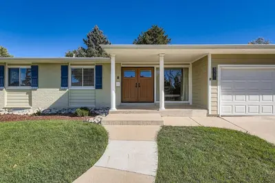 a house with a brown door and a garage at Bright and Cozy Ranch Style House Centennial in Centennial