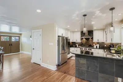 a kitchen with white cabinets and stainless steel appliances at Bright and Cozy Ranch Style House Centennial in Centennial