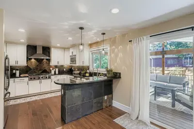 a kitchen with white cabinets and a large window at Bright and Cozy Ranch Style House Centennial in Centennial