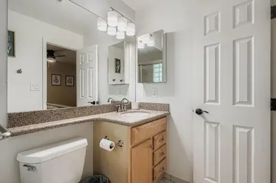 a bathroom with a toilet and a sink and a mirror at Bright and Cozy Ranch Style House Centennial in Centennial