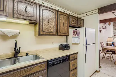 a kitchen with wooden cabinets and a sink and a refrigerator at Snowdance C304 condo in Keystone