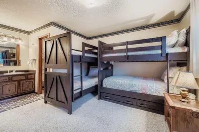 two bunk beds in a room with a sink at Snowdance C304 condo in Keystone