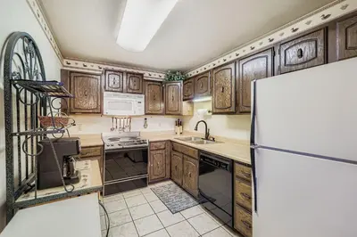 a kitchen with wooden cabinets and a refrigerator at Snowdance C304 condo in Keystone
