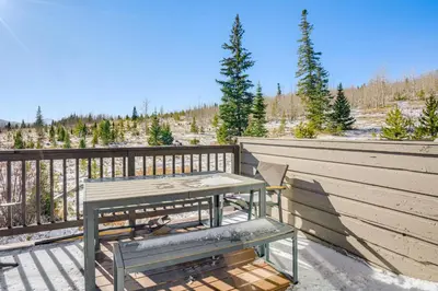 a table and bench on a balcony with a view at Multi-Level Haven 3 Mi to Lake Dillon in Silverthorne