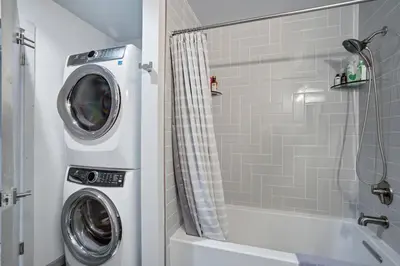 a bathroom with a washing machine next to a shower at 1928 Soda Ridge in Keystone