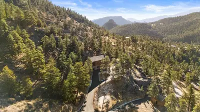 an aerial view of a mountain with trees and a road at Private Hilltop Panoramic Mountain View - Family in Estes Park