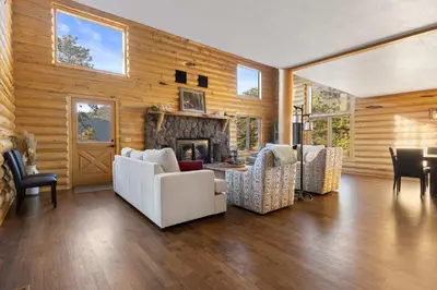 a living room with wooden walls and a fireplace at Private Hilltop Panoramic Mountain View - Family in Estes Park