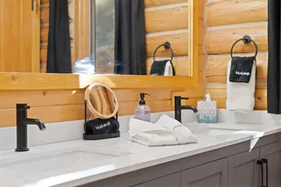 a bathroom with two sinks and a mirror at Private Hilltop Panoramic Mountain View - Family in Estes Park