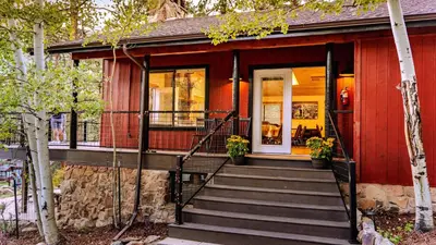 a red house with stairs leading to the front door at Grand Lodge in Estes Park