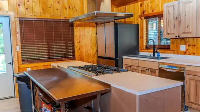 a kitchen with wooden walls and a stove top oven at Grand Lodge in Estes Park