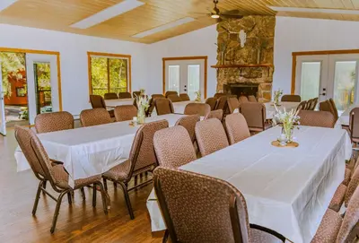 a room with tables and chairs and a fireplace at Grand Lodge in Estes Park