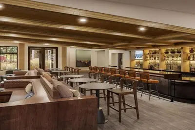 a restaurant with tables and chairs and a bar at Kindred Resort Luxury Ski In, Ski Out 1 Bedroom Residence At The River Run Gondola in Dillon