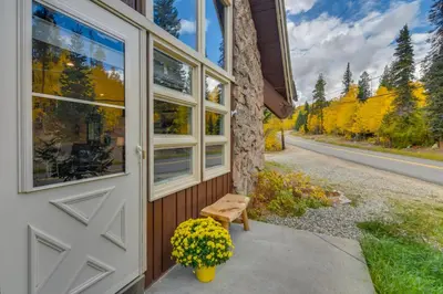 a house with a door and a bench next to a road at The Mountain Chalet - Free Ski Shuttle to Lifts! in Winter Park