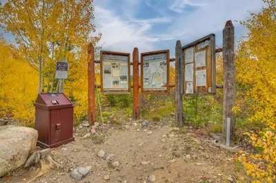 a set of signs in front of yellow trees at The Mountain Chalet - Free Ski Shuttle to Lifts! in Winter Park