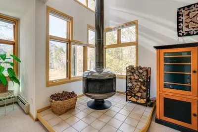 a home with a wood stove in a room with windows at Mtn-View Deck, Workspace! Walkable Frisco Condo in Frisco