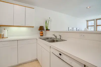 a kitchen with white cabinets and a sink at Mtn-View Deck, Workspace! Walkable Frisco Condo in Frisco