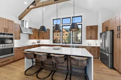 a kitchen with a large white island with bar stools at Alcove 39 in Keystone