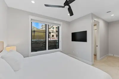 a white bedroom with a large bed and a flat screen tv at Alcove 39 in Keystone