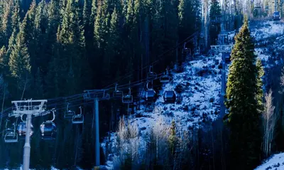 a ski lift in the middle of a snow covered forest at Alcove 39 in Keystone
