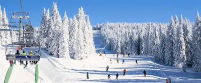 a group of people skiing down a snow covered ski slope at Saddle Ridge, 0021 in Granby