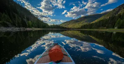 a boat on a river with its reflection in the water at Saddle Ridge, 0021 in Granby