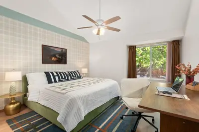 a bedroom with a bed and a desk with a laptop at Game Room Paradise, Firepit & Outdoor Movies in Arvada