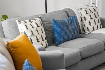 a gray couch with pillows on it in a living room at Family Home - Dog-Friendly - Fire Pit in Arvada