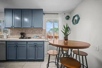a kitchen with blue cabinets and a table with stools at Family Home - Dog-Friendly - Fire Pit in Arvada