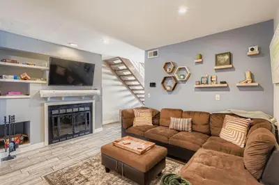 a living room with a brown couch and a fireplace at The Santa Fe Spot Walk to Eats, Drinks and Fun in Denver