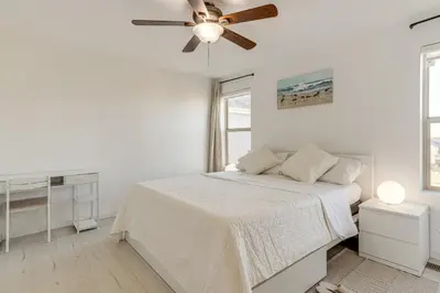 a white bedroom with a bed and a ceiling fan at Near Denver airport 20 min away from downtown in DEN