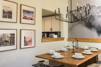 a dining room with a wooden table and a chandelier at Skyline Lodge in Idaho Springs