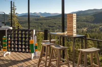 a set of stools on a deck with mountains in the background at Skyline Lodge in Idaho Springs