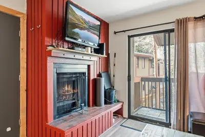 a living room with a fireplace with a flat screen tv at Mountain Charmer Steps to Main St and Trails in Frisco