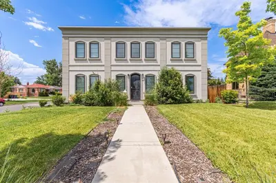 a large white house with a sidewalk in front of it at Beautiful Denver City Park Home in Denver
